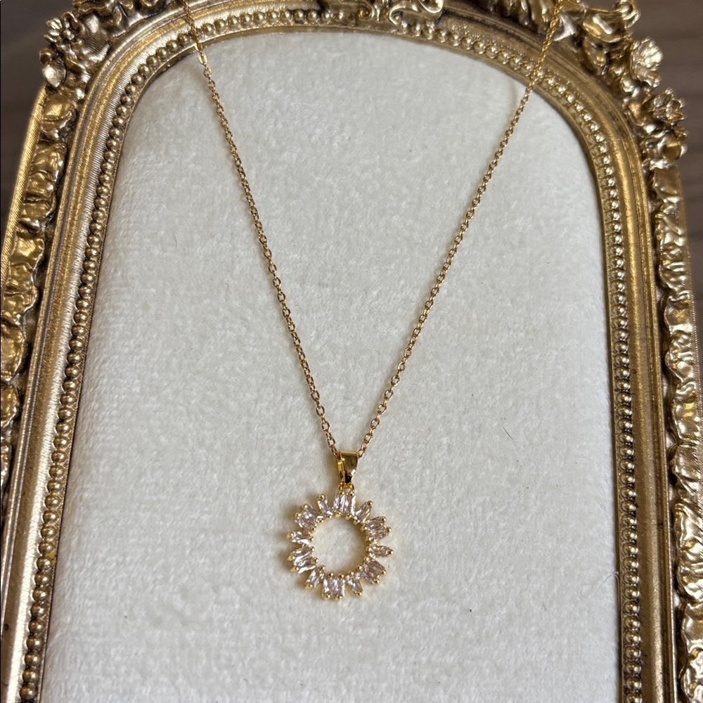 Gold-tone sunburst pendant necklace with baguette-cut faux diamond stones